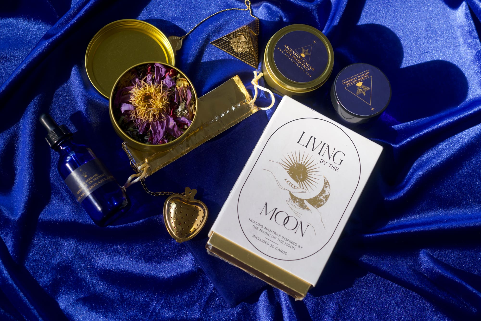 Ascension Azul full collection on blue velvet — tins, oils, and botanicals
